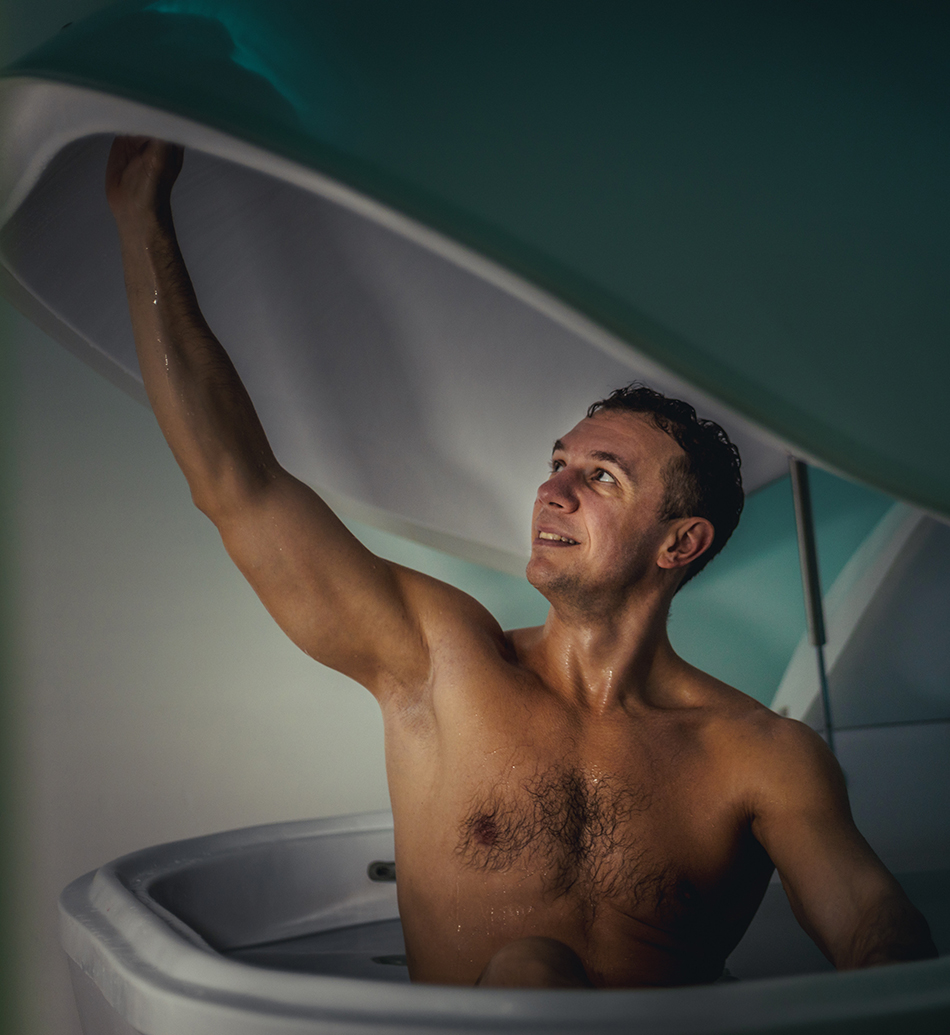 Relaxed man is floating in a sensory deprivation tank. He is very relaxed. Wellness and Spa concept.